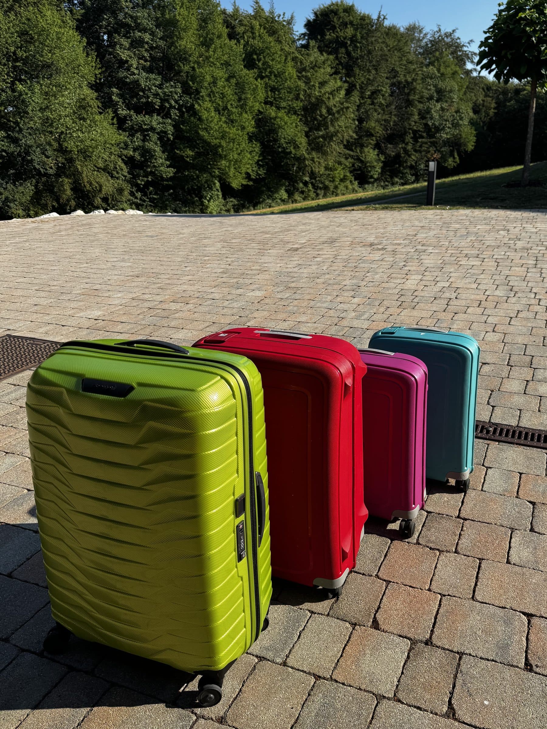 Four colourful suitcases lined up at home before a trip